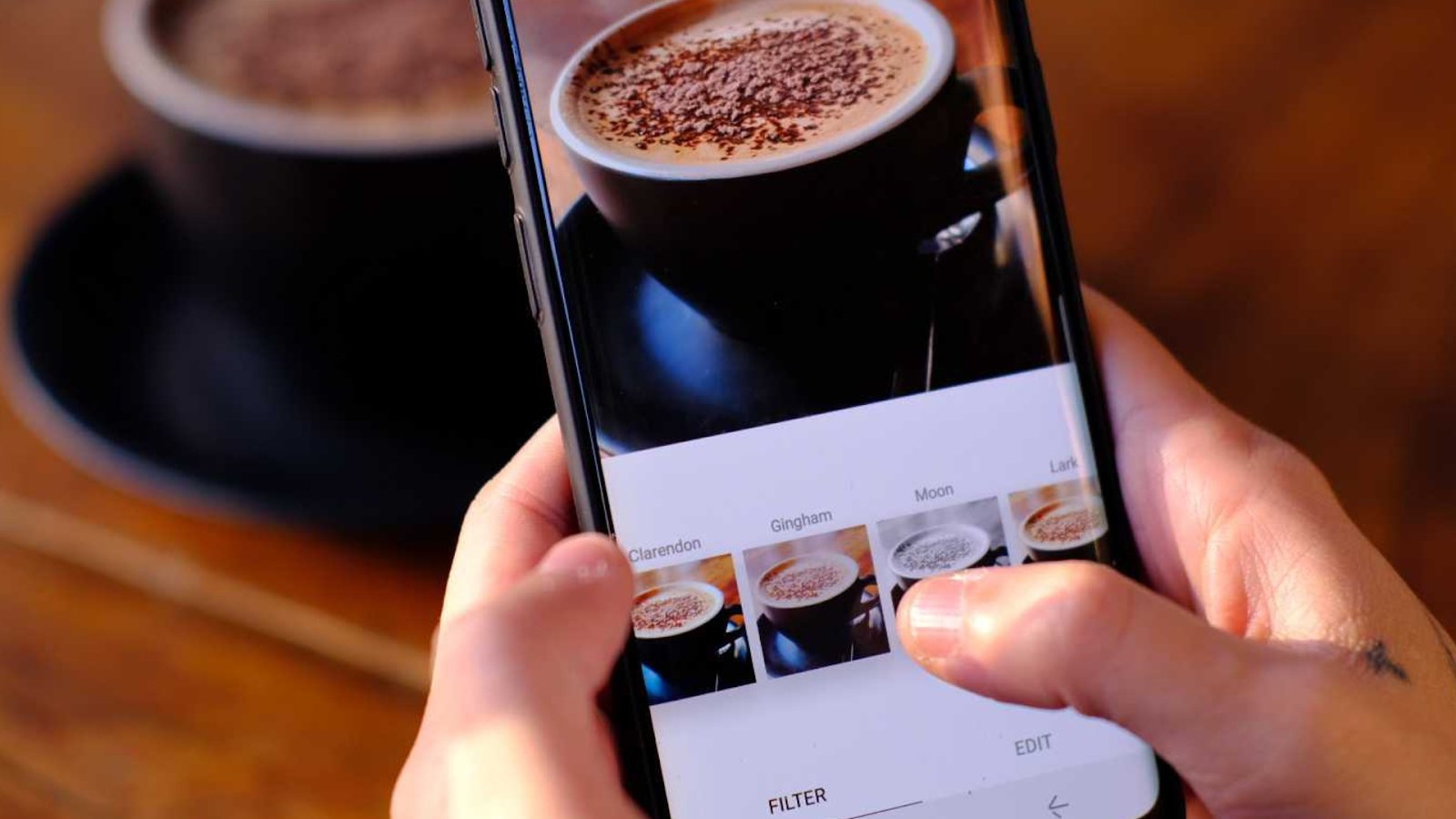 カフェラテをスマホで撮影して加工する手元